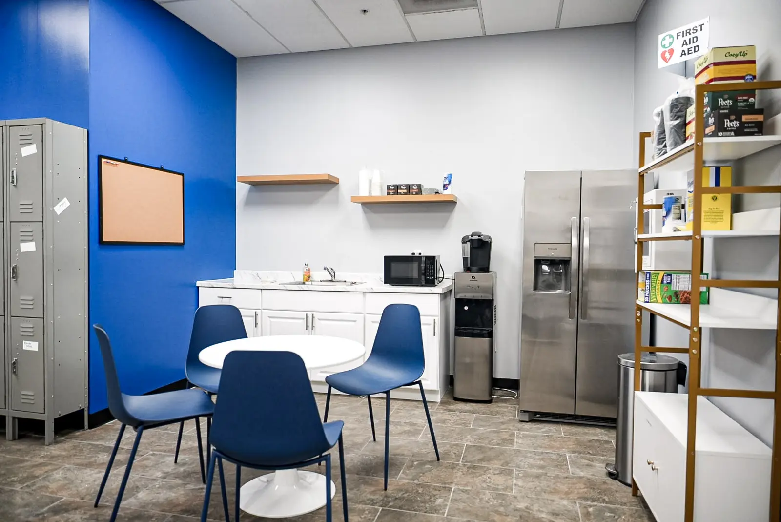 Finished break room with a kitchenette, lockers, shelving and a blue feature wall