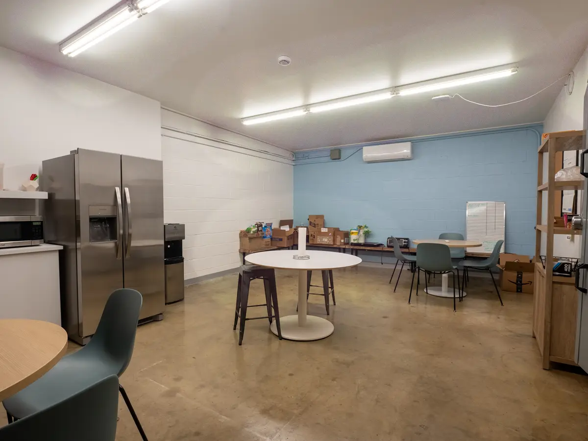 Commercial break room with a kitchenette, appliances and dining tables