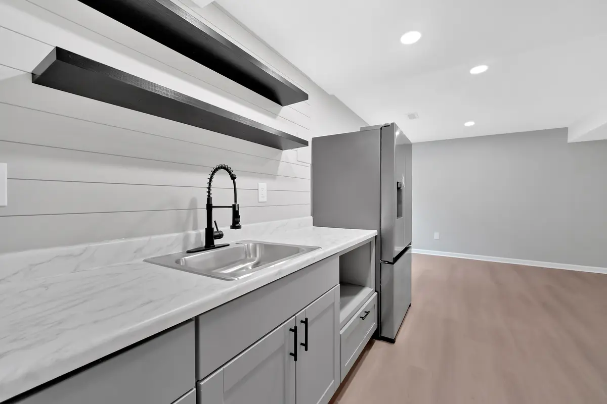 Installed kitchenette with a shiplap wall, stone counter and new appliances