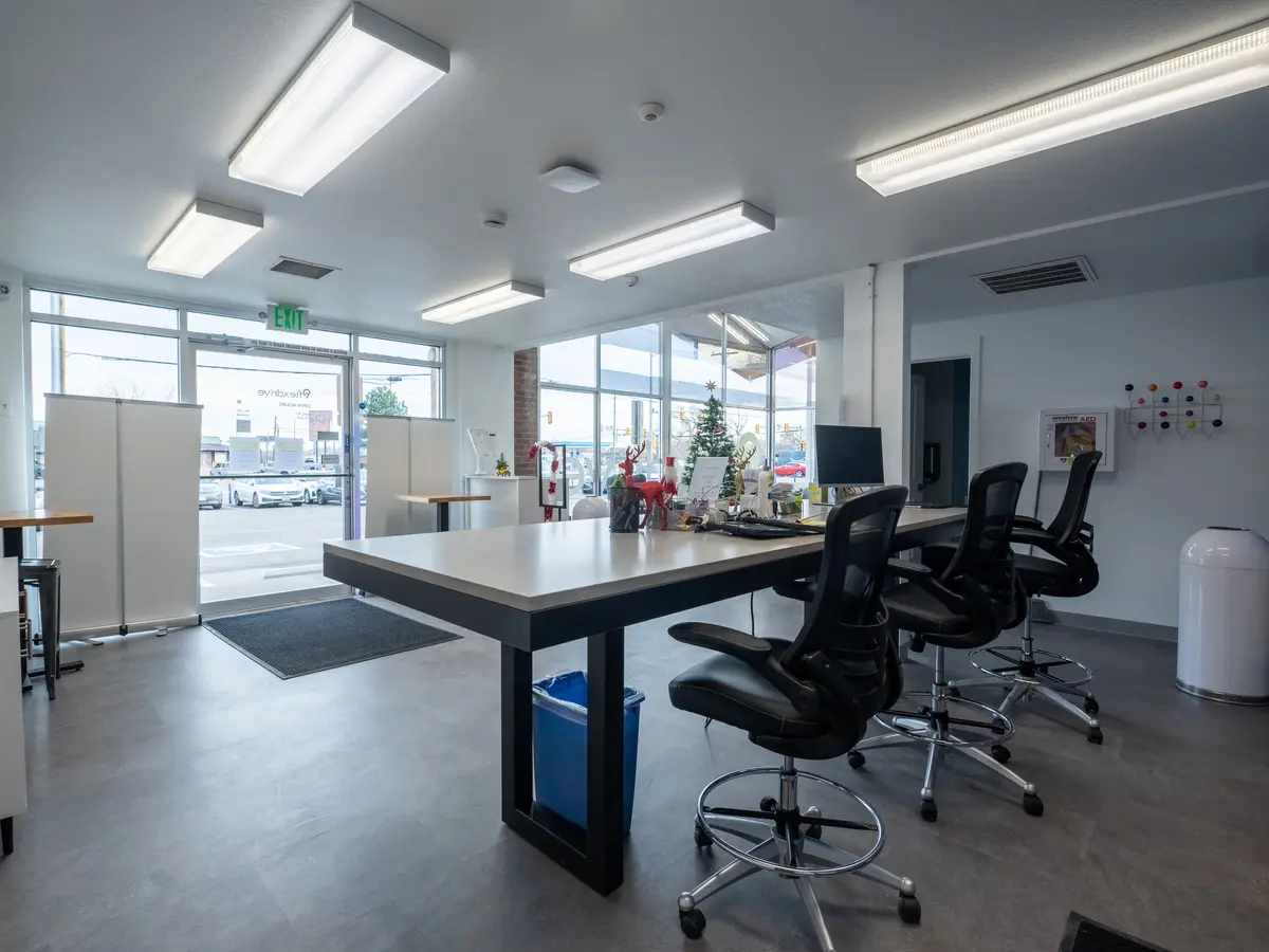 Open office fit-out with a shared work table, task chairs and new flooring