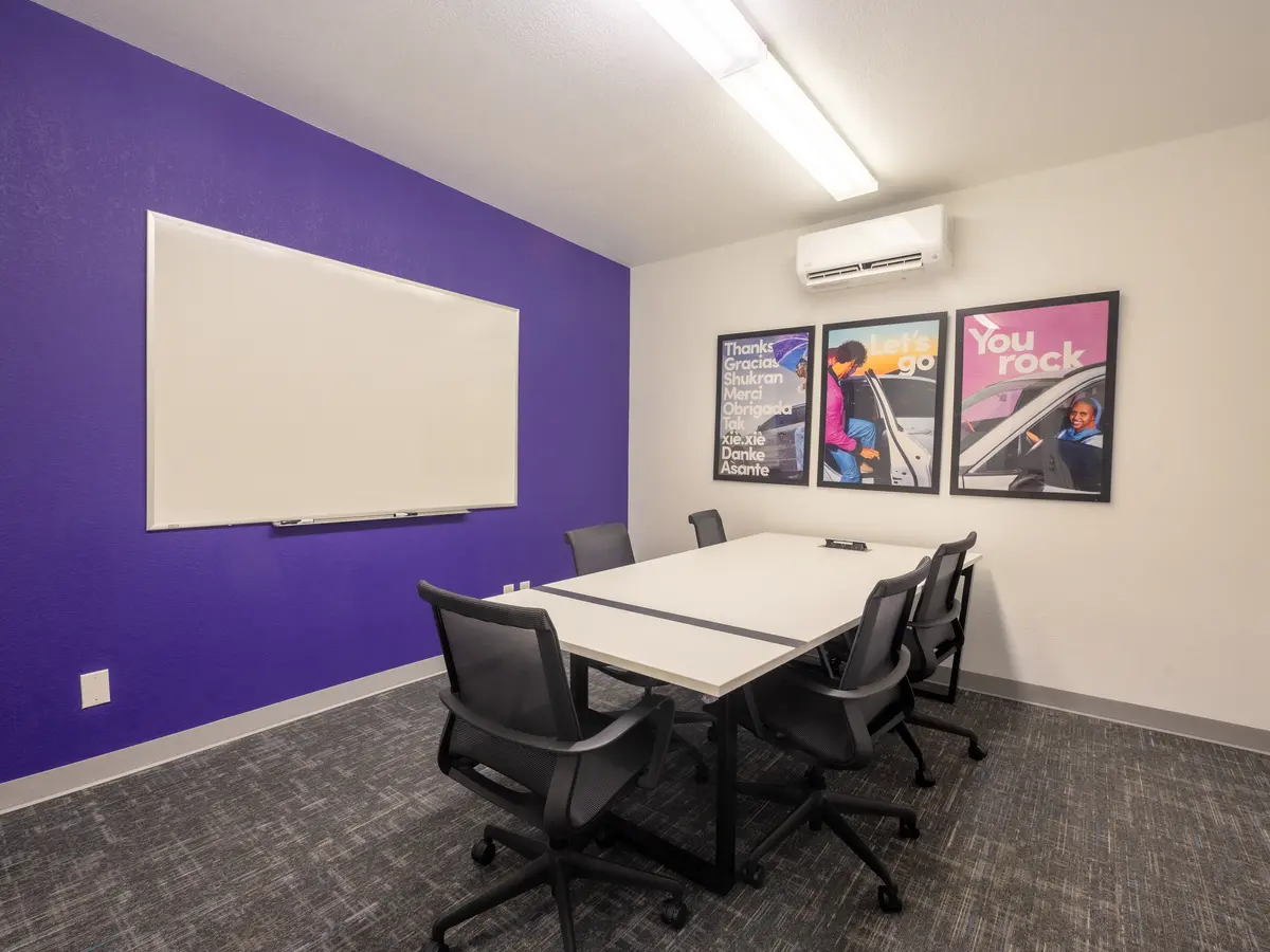 Finished training room with a whiteboard wall, conference table and new lighting